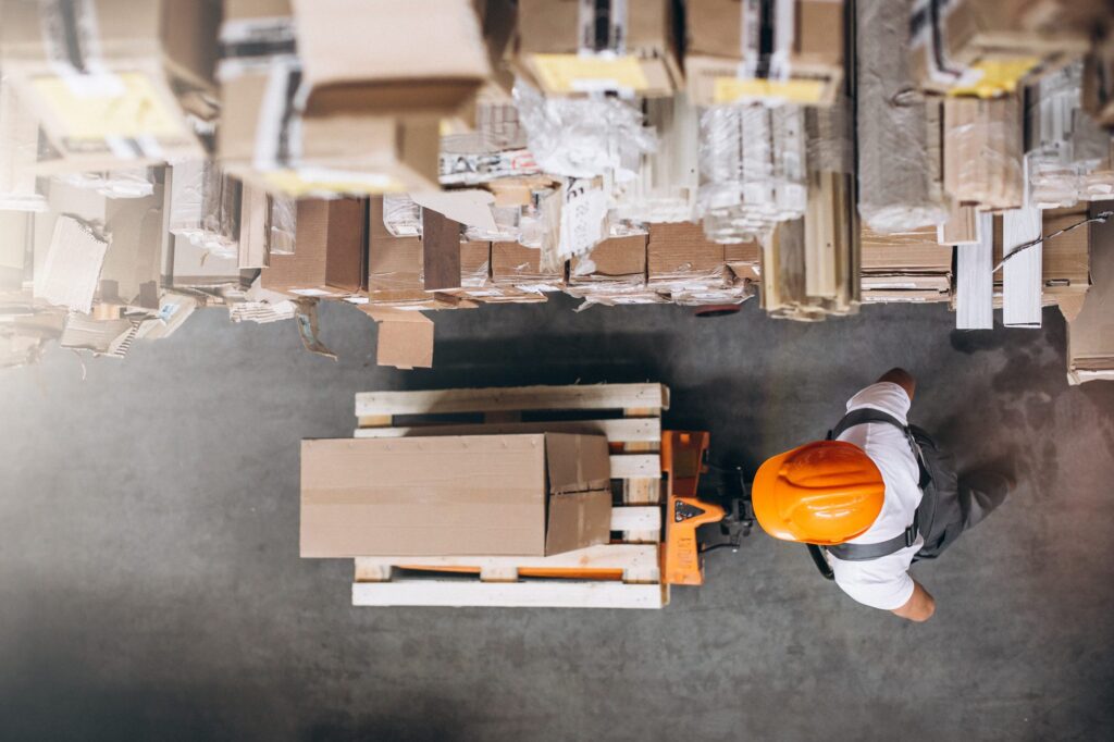 Homem fazendo a logística da empresa com um carro picking logística.