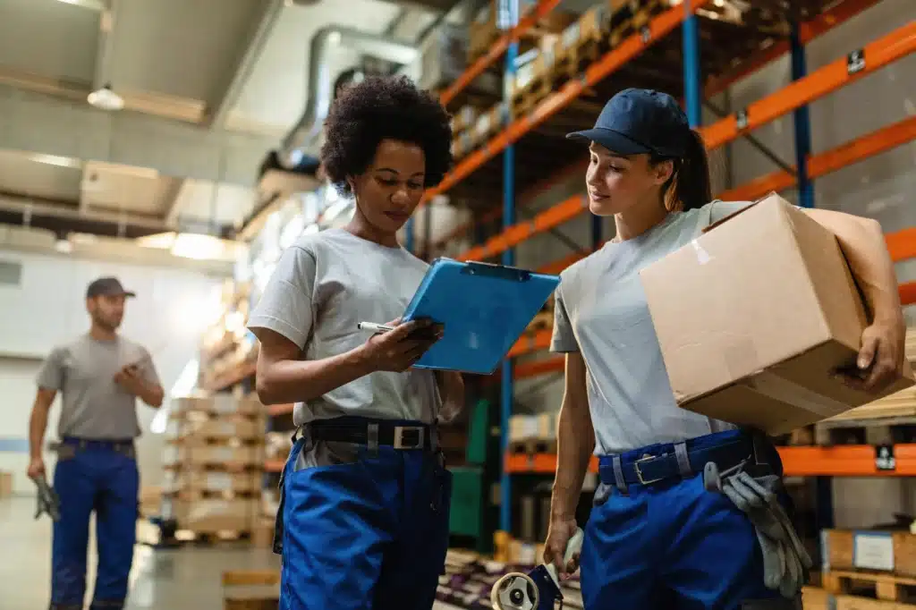 funcionárias de galpão logístico conversando sobre a organização do espaço e o uso de caixas pallets